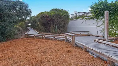 a wooden deck with benches next to a building at Hidden Beach 101 in Santa Rosa Beach