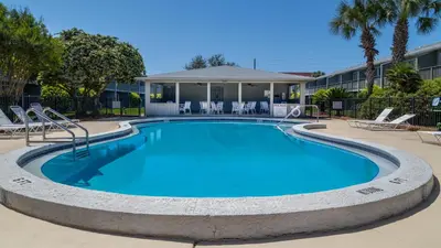 a large swimming pool with chairs and a building at Hidden Beach 101 in Santa Rosa Beach