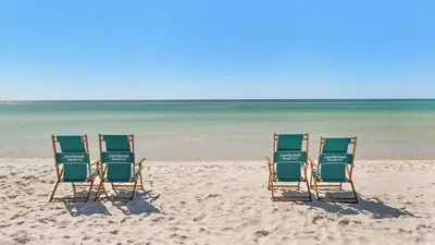 two beach chairs sitting in the sand on the beach at Beachcrest 603 in Santa Rosa Beach