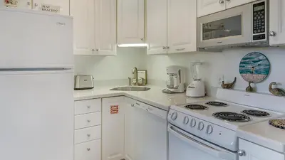 a white kitchen with a stove and a sink at Hidden Beach 117 in Santa Rosa Beach