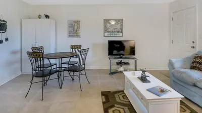 a living room with a table and chairs and a couch at Hidden Beach 117 in Santa Rosa Beach