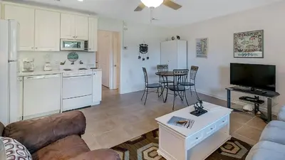 a living room with a couch a table and a kitchen at Hidden Beach 117 in Santa Rosa Beach