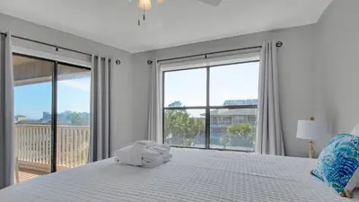 a white bedroom with a large bed and large windows at Beachwood Villas 12I in Santa Rosa Beach