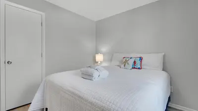 a bedroom with a white bed with towels on it at Beachwood Villas 12I in Santa Rosa Beach
