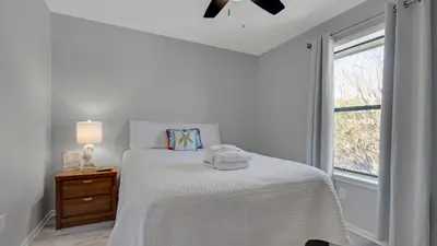 a white bedroom with a bed and a window at Beachwood Villas 12I in Santa Rosa Beach