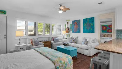 a bedroom with a bed and a living room at Hidden Beach 228 in Santa Rosa Beach