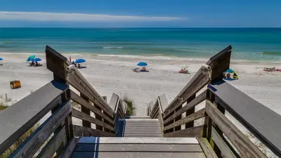 a stairway leading to a beach with umbrellas at Hidden Beach 228 in Santa Rosa Beach