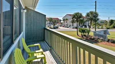 two chairs on a porch with a view of a street at Hidden Beach 240 in Santa Rosa Beach
