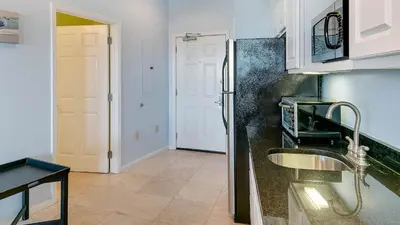 a kitchen with a sink and a refrigerator at Inn At Seacrest 405 in Rosemary Beach