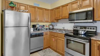 a kitchen with wooden cabinets and a stainless steel refrigerator at Beachcrest 806 in Santa Rosa Beach