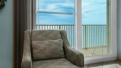 a chair sitting in front of a window at Beachcrest 902 in Santa Rosa Beach