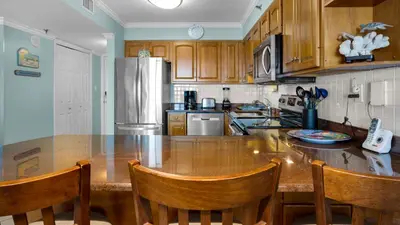a kitchen with a large wooden table with chairs at Beachcrest 902 in Santa Rosa Beach