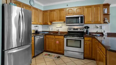 a kitchen with wooden cabinets and stainless steel appliances at Beachcrest 902 in Santa Rosa Beach