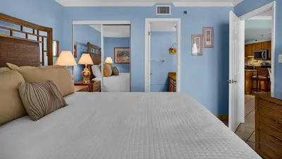 a bedroom with a large bed and blue walls at Beachcrest 902 in Santa Rosa Beach