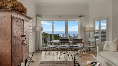 a living room with a table and chairs at Legacy 101 in Santa Rosa Beach
