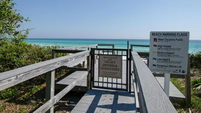 a boardwalk leading to the beach with a sign at Legacy 101 in Santa Rosa Beach
