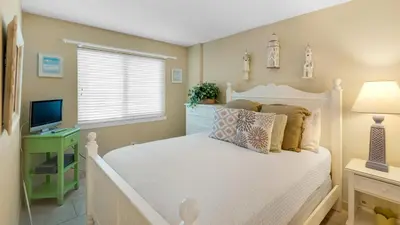 a bedroom with a white bed and a television at Beachcrest 903 in Santa Rosa Beach