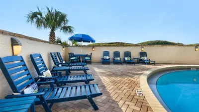 a group of blue chairs sitting next to a swimming pool at Beachcrest 903 in Santa Rosa Beach