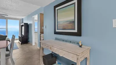 a living room with a table and a picture on the wall at Beachcrest 904 in Santa Rosa Beach