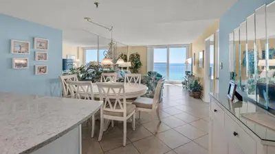 a kitchen and dining room with a table and chairs at Beachcrest 906 in Santa Rosa Beach