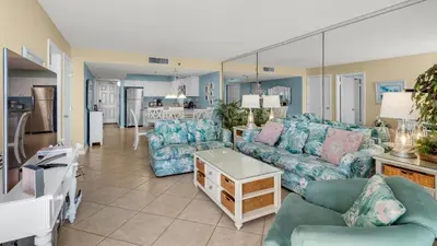 a living room with blue couches and a kitchen at Beachcrest 906 in Santa Rosa Beach