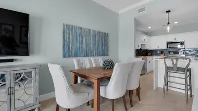 a kitchen and dining room with a wooden table and chairs at Legacy 403 in Santa Rosa Beach