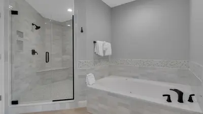 a bathroom with a tub and a glass shower at Legacy 403 in Santa Rosa Beach
