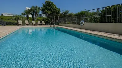 a swimming pool with blue water in front of a building at Legacy 403 in Santa Rosa Beach