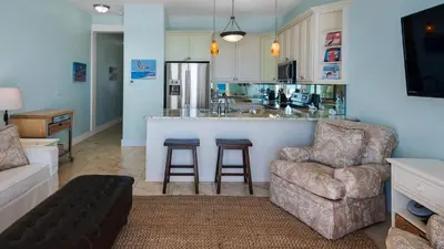 a living room with a couch and a kitchen at Leeward I Unit 8 in Santa Rosa Beach