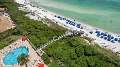 an aerial view of a beach with umbrellas and a swimming pool at Beachcrest 1005 in Santa Rosa Beach
