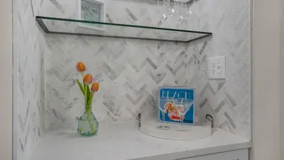 a bathroom with a sink with a vase with flowers in it at Beachcrest 1005 in Santa Rosa Beach