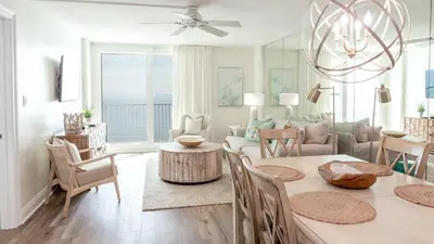 a dining room and living room with a table and chairs at Beachcrest 1005 in Santa Rosa Beach