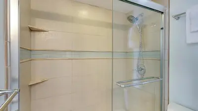 a shower with a glass door in a bathroom at Beachcrest 1002 in Santa Rosa Beach