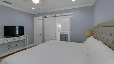 a bedroom with a bed and a flat screen tv at Monterey Condos C301 in Seacrest