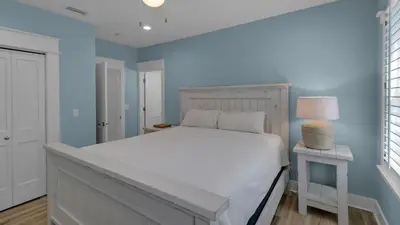 a bedroom with a white bed and a blue wall at Monterey Condos C301 in Seacrest