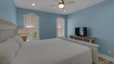 a bedroom with a white bed and a tv at Monterey Condos C301 in Seacrest