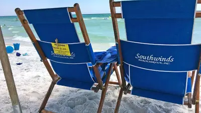 a blue beach chair sitting on the beach at Moon Glow in Santa Rosa Beach
