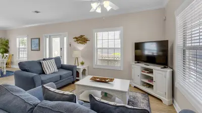 a living room with a couch and a tv at Moon Glow in Santa Rosa Beach