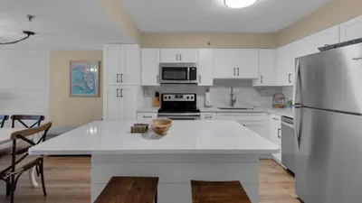 a kitchen with white cabinets and a white refrigerator at Beachcrest 1101 in Santa Rosa Beach