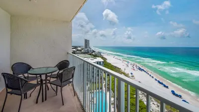 a balcony with a table and chairs and the beach at Beachcrest 1101 in Santa Rosa Beach