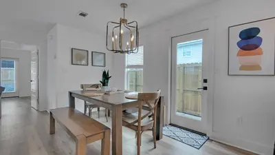 a dining room with a table and chairs and a chandelier at Soul Shine in Santa Rosa Beach