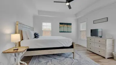 a white bedroom with a bed and a television at Soul Shine in Santa Rosa Beach