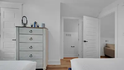 a bedroom with two beds and a dresser with a mirror at Soul Shine in Santa Rosa Beach