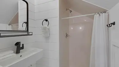 a white bathroom with a shower curtain and a mirror at Soul Shine in Santa Rosa Beach
