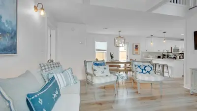 a living room with a couch and chairs and a kitchen at Soul Shine in Santa Rosa Beach