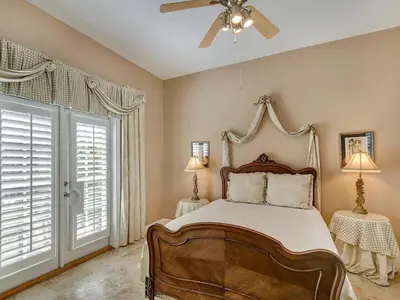 a bedroom with a bed and a ceiling fan at Mon Petit Chateau in Panama City Beach