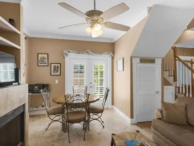 a living room with a dining room table and a ceiling fan at Mon Petit Chateau in Panama City Beach