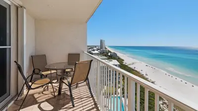 a balcony with a table and chairs and the beach at Beachcrest 1201 in Santa Rosa Beach