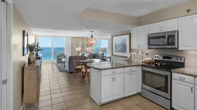 a kitchen and living room with a view of the ocean at Beachcrest 1201 in Santa Rosa Beach
