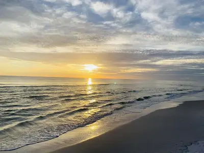 a sunset on a beach with the ocean at Beachcrest 1102 in Santa Rosa Beach